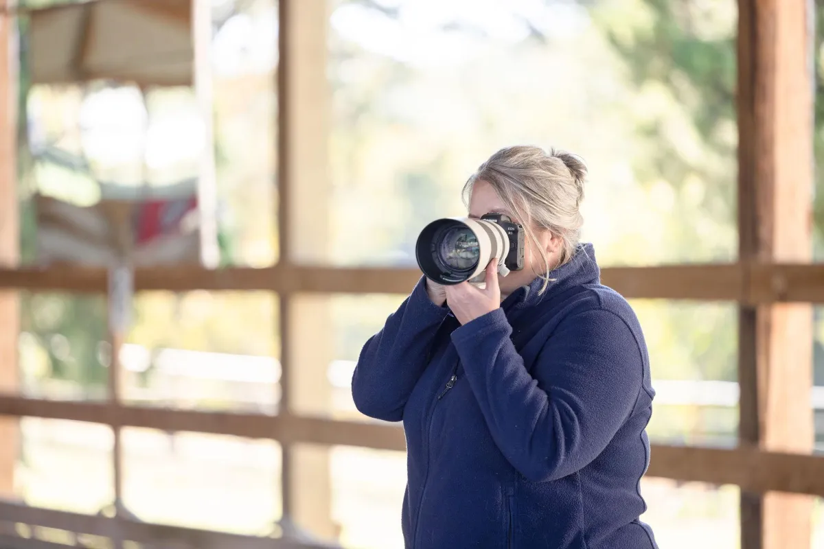 Equine Photographer posed to take a picture in covered arena