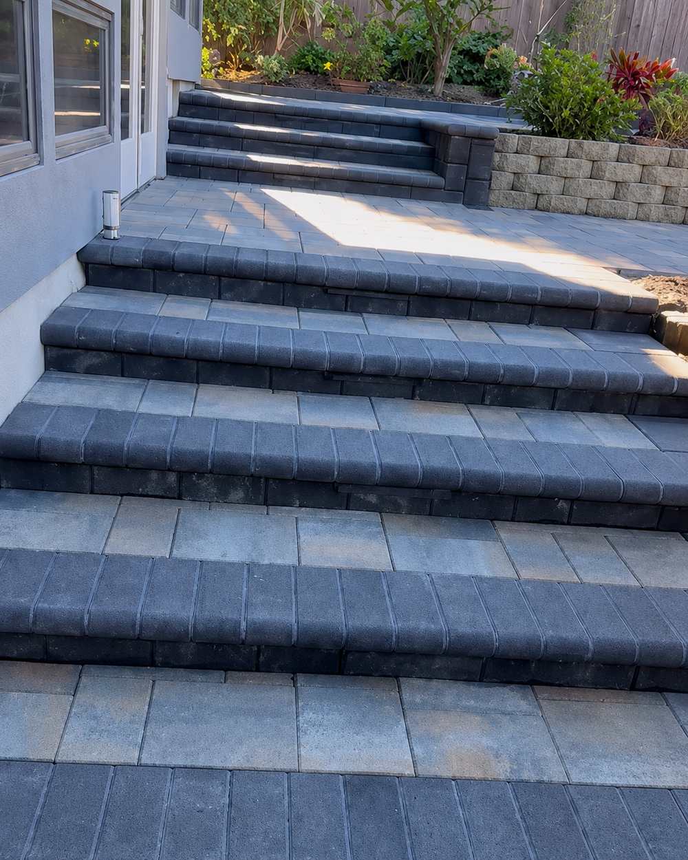 Backyard paver patio with steps and retaining wall