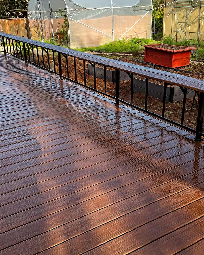 Long stained wood deck with black metal railing
