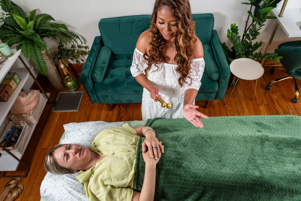 A woman meditates peacefully in the lotus position on a cliff edge, overlooking layers of misty mountains.