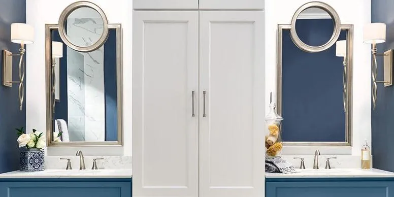 Blue double bathroom vanity cabinets with white countertops, mirrors, and wall sconces