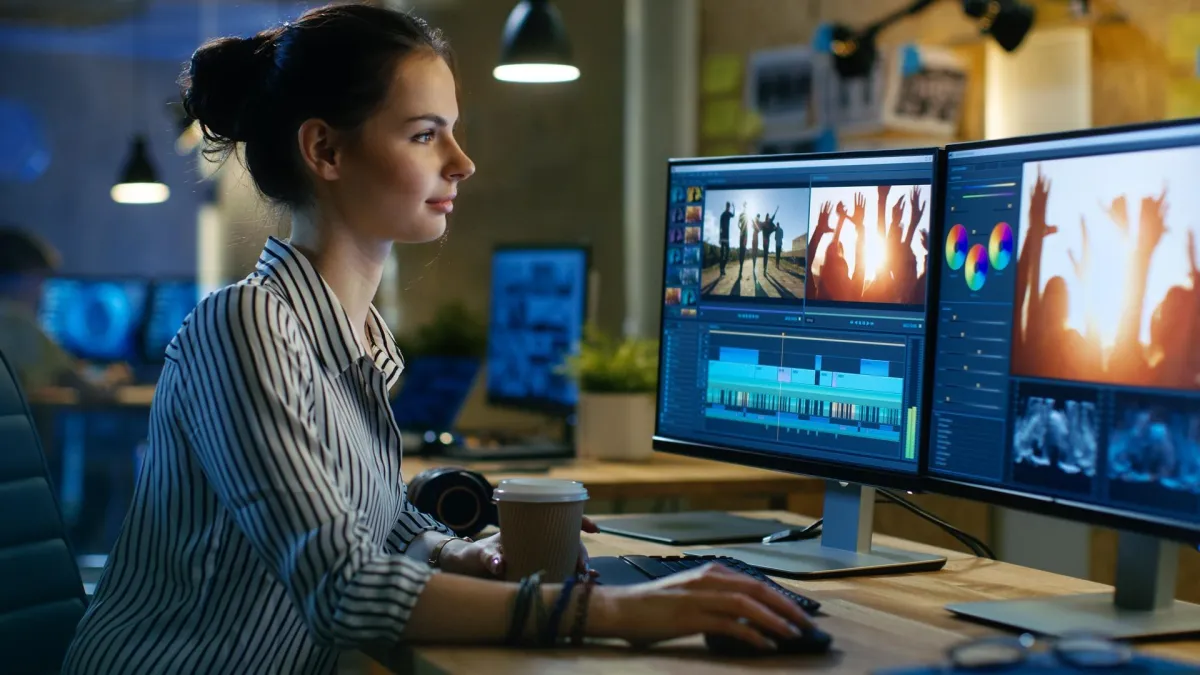 Corporate woman sitting at desk using video editing tools to edit a video