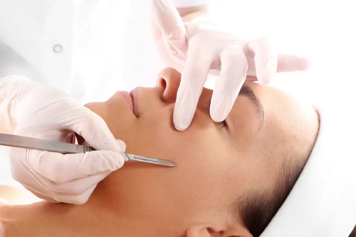 person holding clear glass bottle