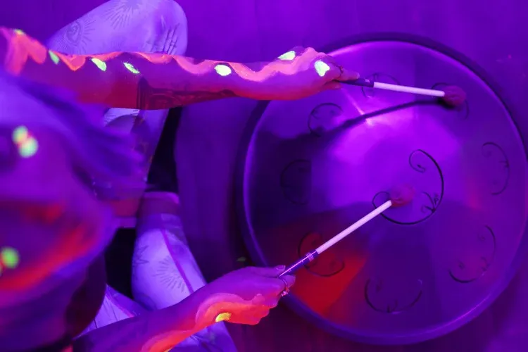 Half-body portrait of a female sound therapist, age 35, holding a tuning fork at chest level, calm expression, studio lighting, perfectly isolated with no background or shadows for flexible layout use.