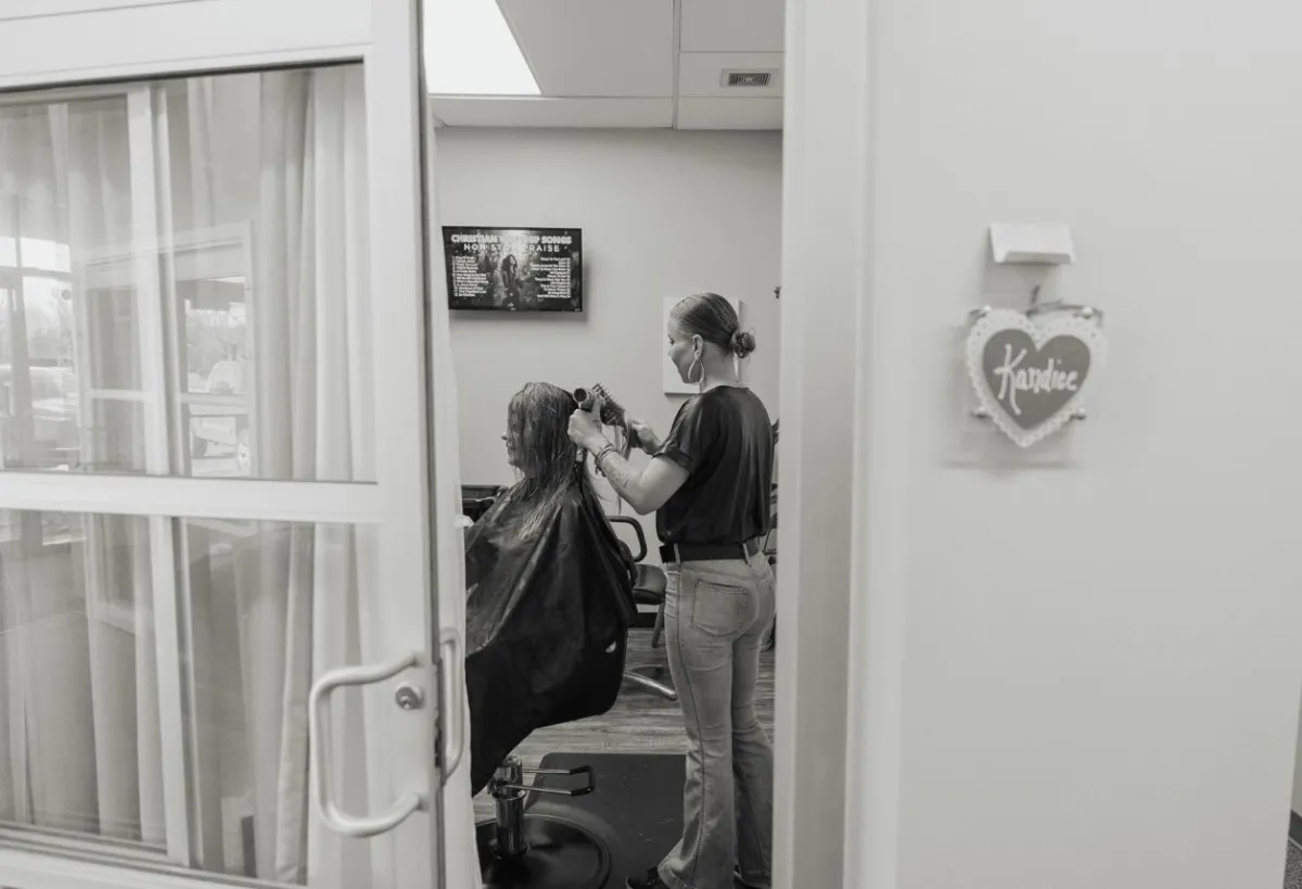 Kandice styling a client's hair at her salon suite, Hair by Kandice.
