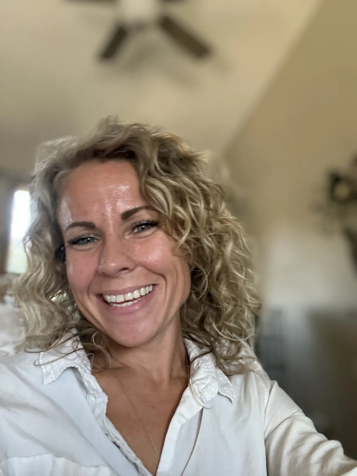 Kandice smiling in a white shirt.
