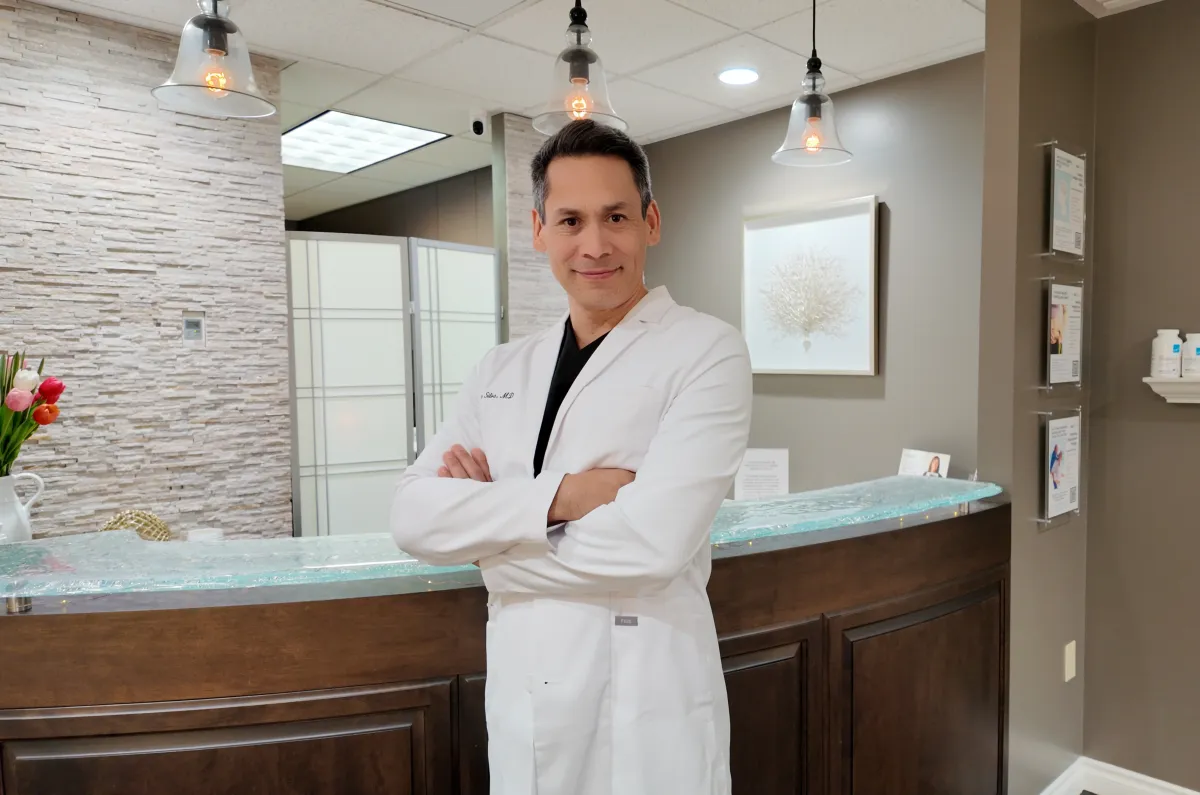 Dr. Otoño Silva in white scrubs at Interventional Orthopedics of Washington (IOW) Clinic, specializing in regenerative medicine treatments.