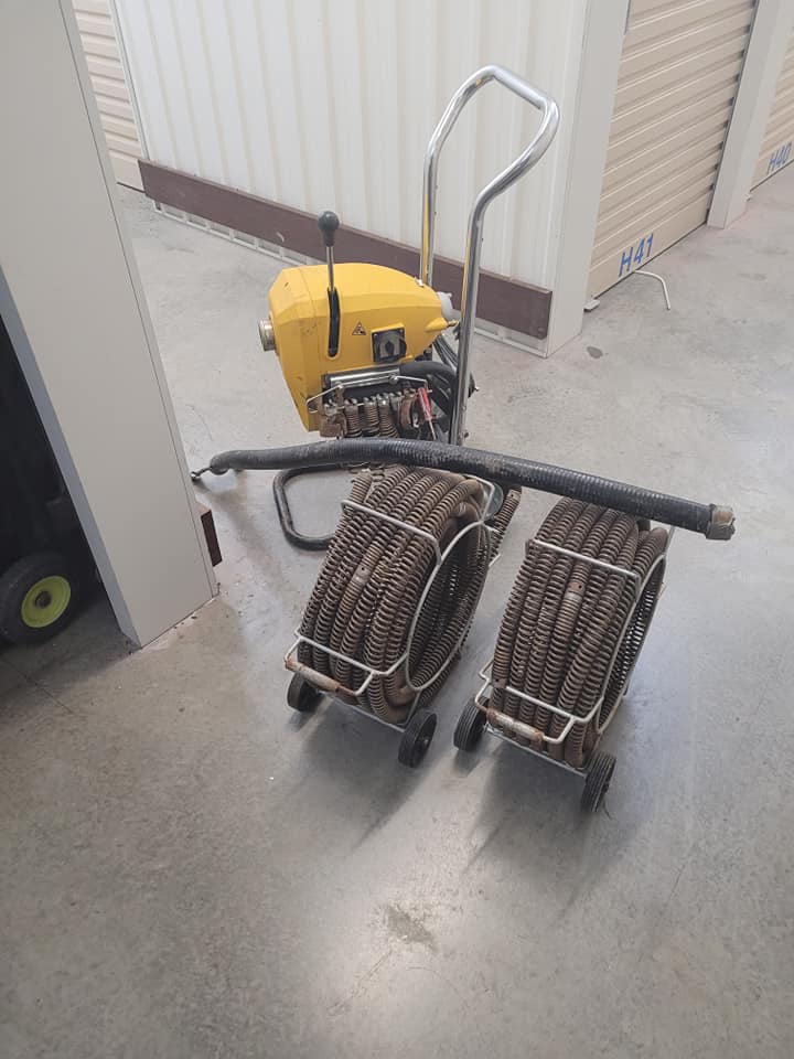 Professional blocked drain plumber in Greenslopes, Brisbane using 100 ft+ electric drain cleaning machine (electric eel) to clear tree roots and sewer blockages.