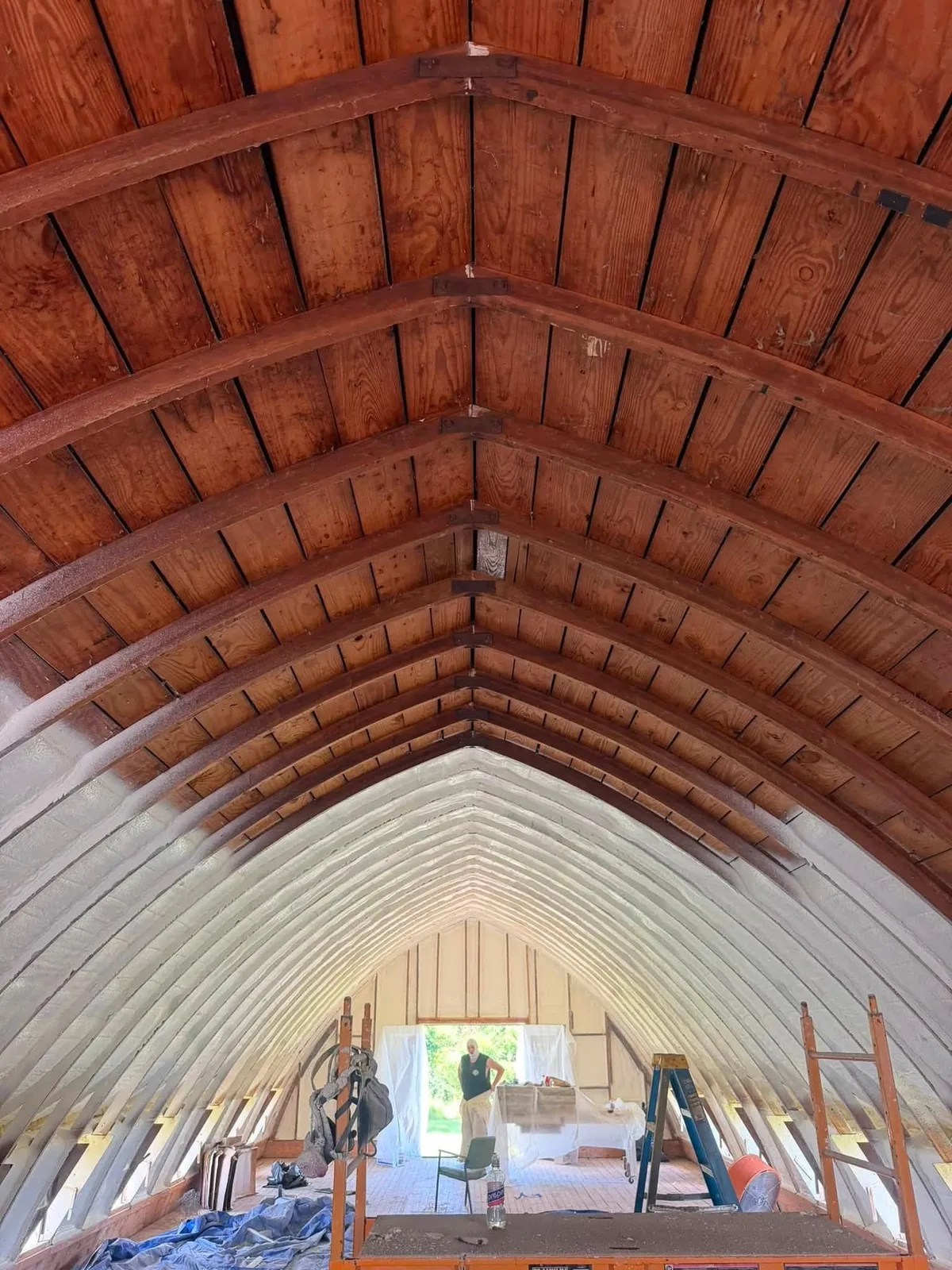 Closed cell spray foam under the arched rafters of a barn loft in Concord, Michigan