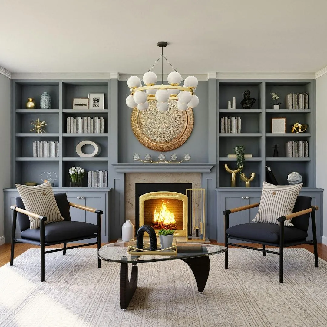 Modern living room design featuring two stylish chairs, a sleek glass coffee table, and a cozy fireplace, complemented by decorative shelving with books and accents, embodying DHD Interior Designs' philosophy of creating personalized, functional spaces.