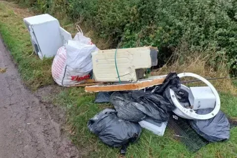 Household junk dumped at side of road illegally 