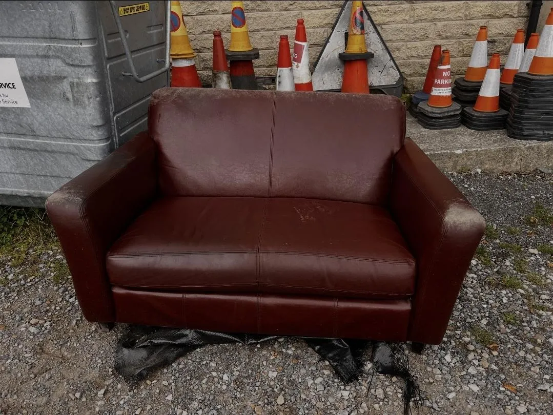 Two-seater sofa ready to be loaded onto a rubbish removal van in Huddersfield