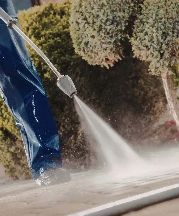 Close-up of professional driveway pressure washing service removing dirt and grime.