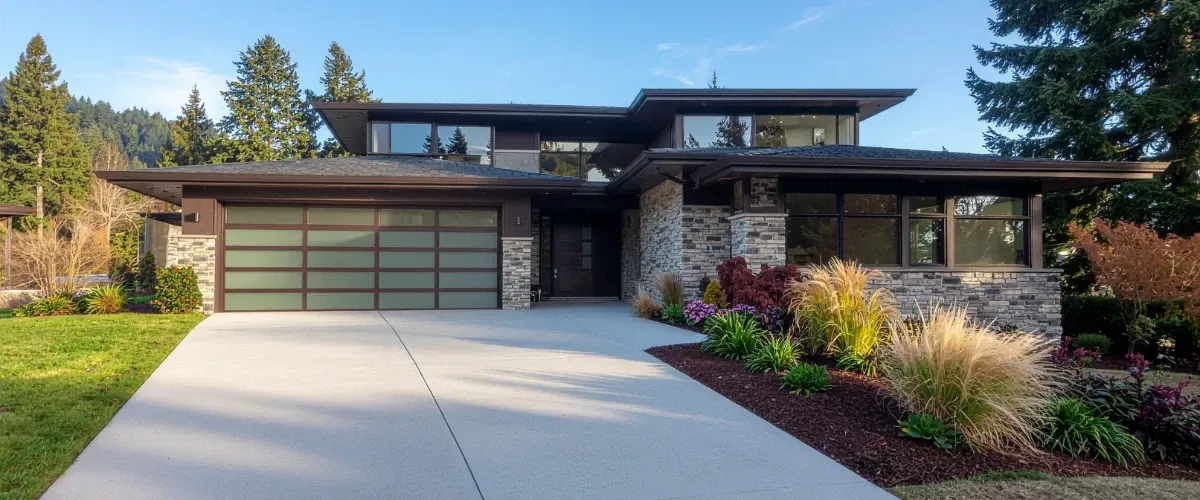 Modern home exterior with freshly cleaned driveway and landscaped front yard.
