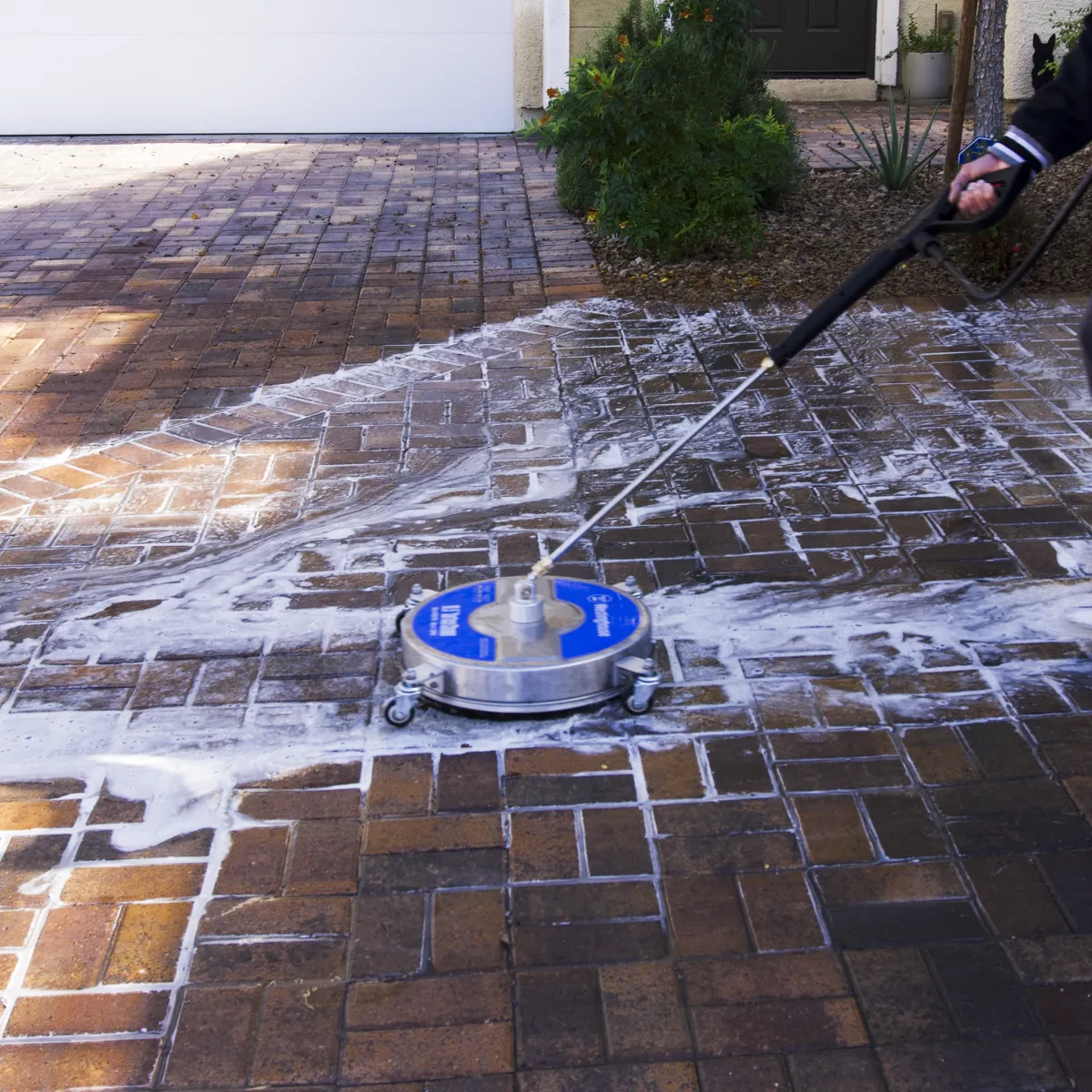 Professional surface cleaning of a paver driveway removing dirt and grime with consistent pressure and detergent foam. Elite Hydro Works improves curb appeal and extends the life of paver driveways followed by sealing.