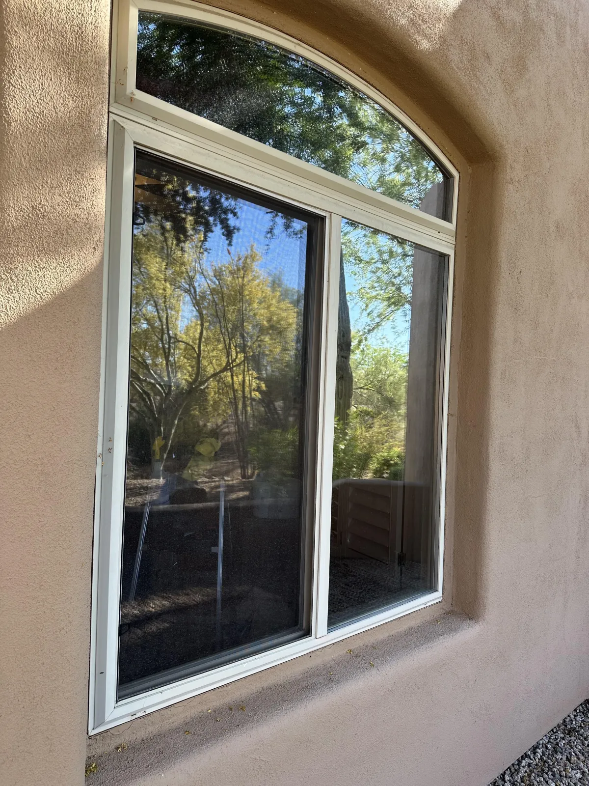 Professional window tint installer carefully applying film to a residential window