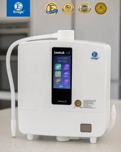 Enagic LeveLuk K8 water ionizer displaying the Kangen Water menu on its digital touch screen, set on a house.