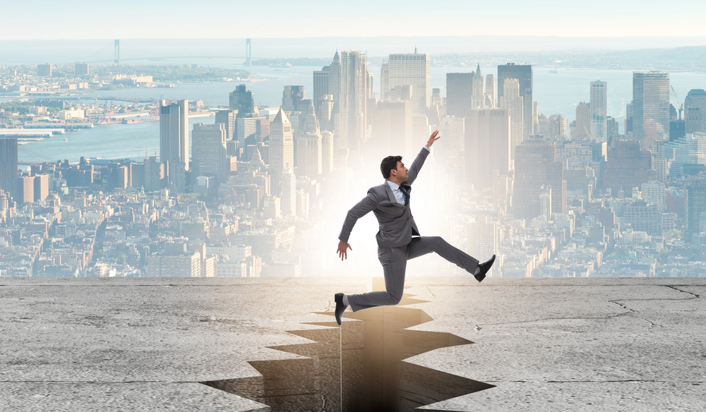 Einen erfolgreichen man in einem Großstadt der über einen Riss springt