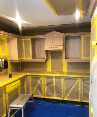 A kitchen all taped up ready for spraying