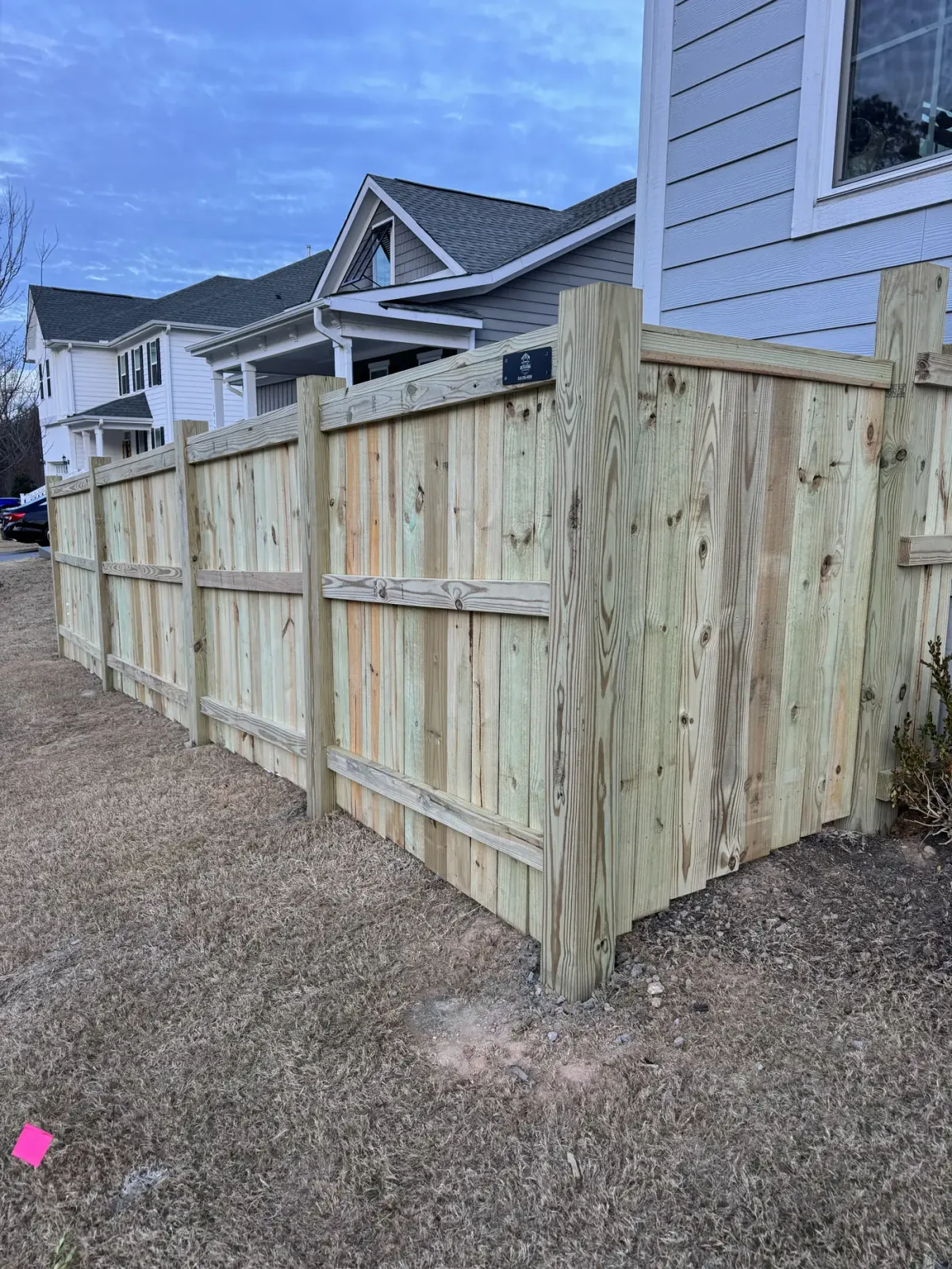 New pressure-treated wood privacy fence with gate installed in Apex, NC