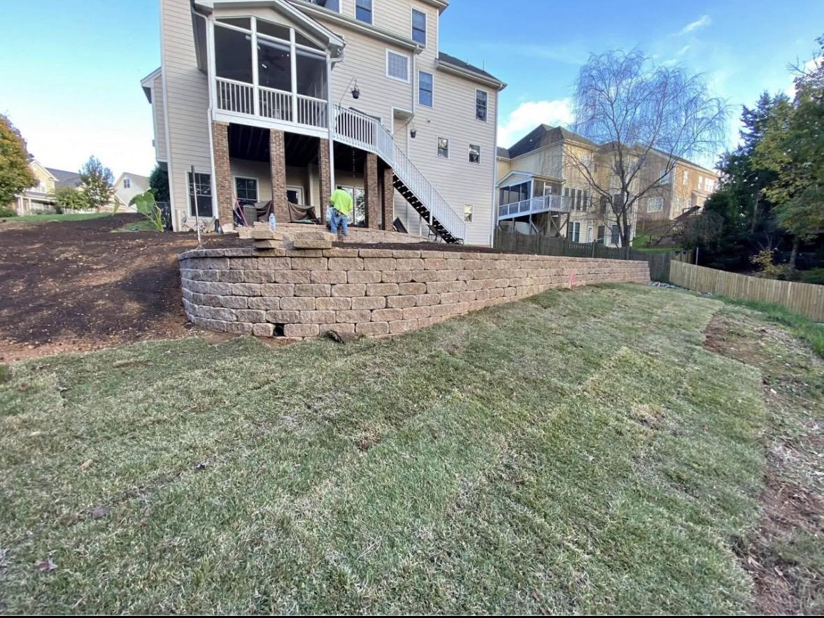Block retaining wall on a sloped backyard with new sod in the Triangle, NC