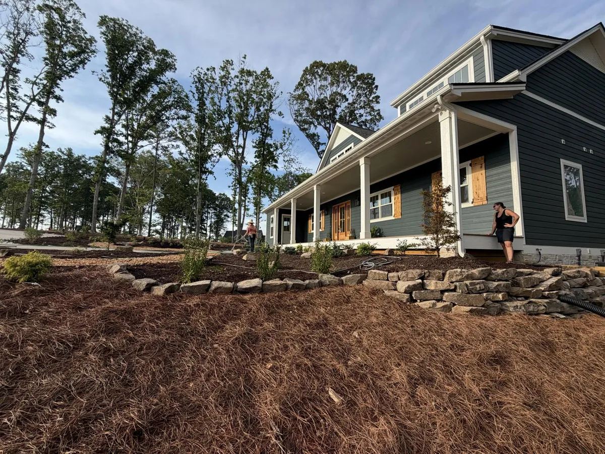 Boulder retaining wall and pine straw beds along a new home in the Triangle, NC