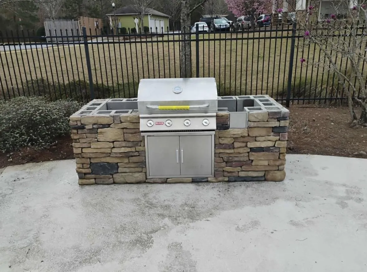 Stone outdoor kitchen with built-in grill on a concrete patio in the Triangle, NC