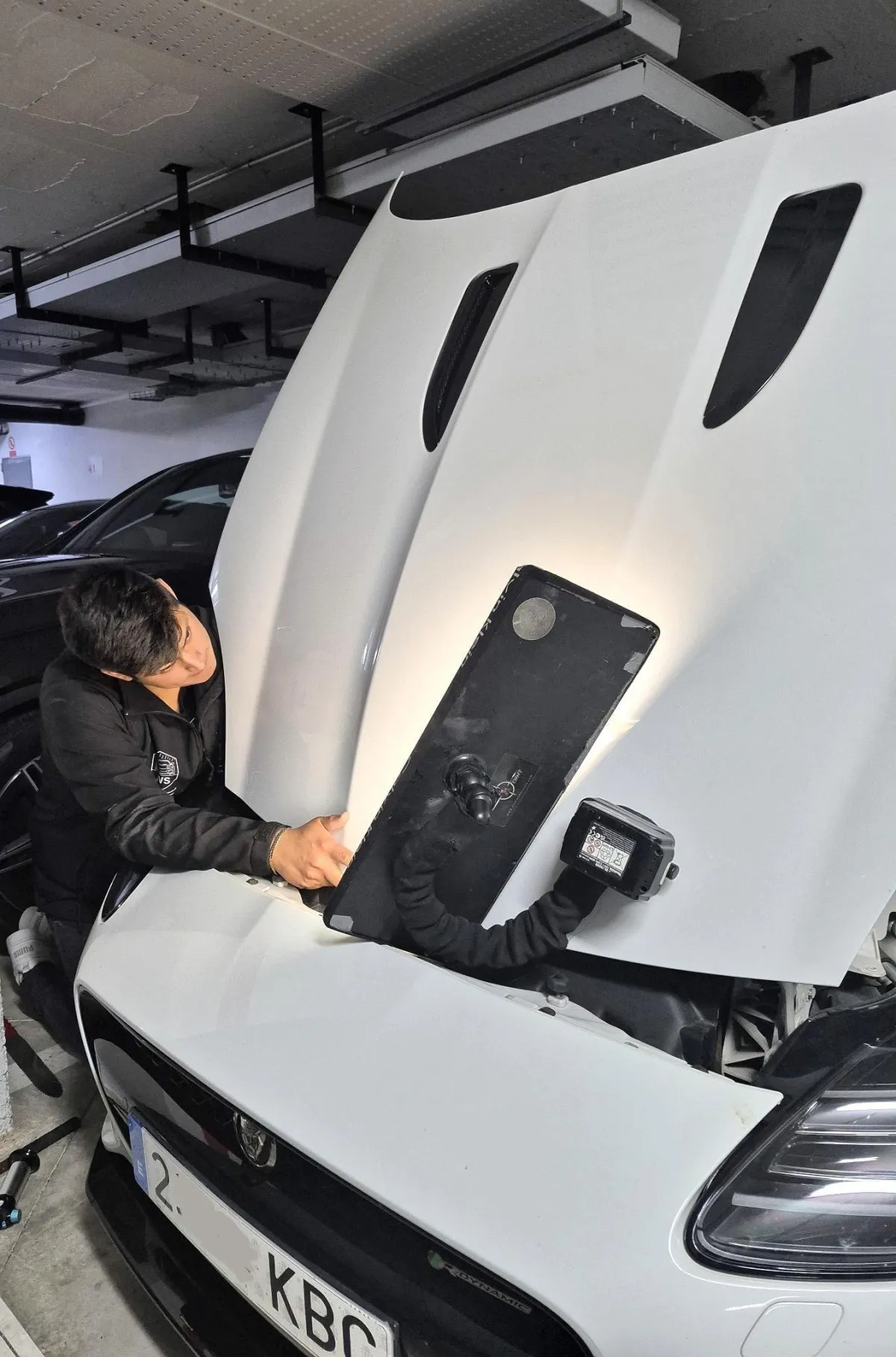 Detalle de reparación de bollos sin pintar en coche de lujo