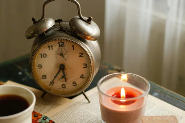 Clock and candle signifying time to breathe and relax.