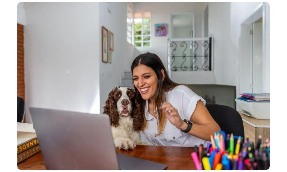Woman and dog smiling at laptop