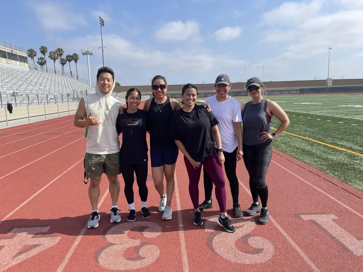 Group of runners posing on track for Primitive Run Club