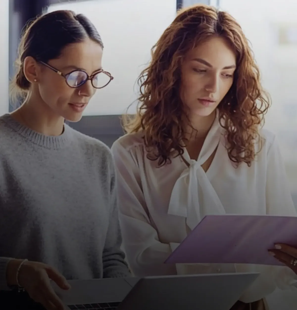 Two female healthcare practitioners reviewing patient data.