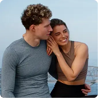 Happy couple smiling by the water.