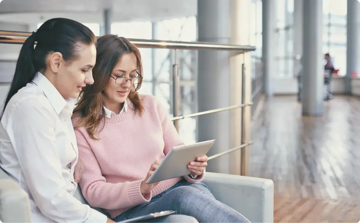 Two healthcare practitioners looking at health data on a tablet.