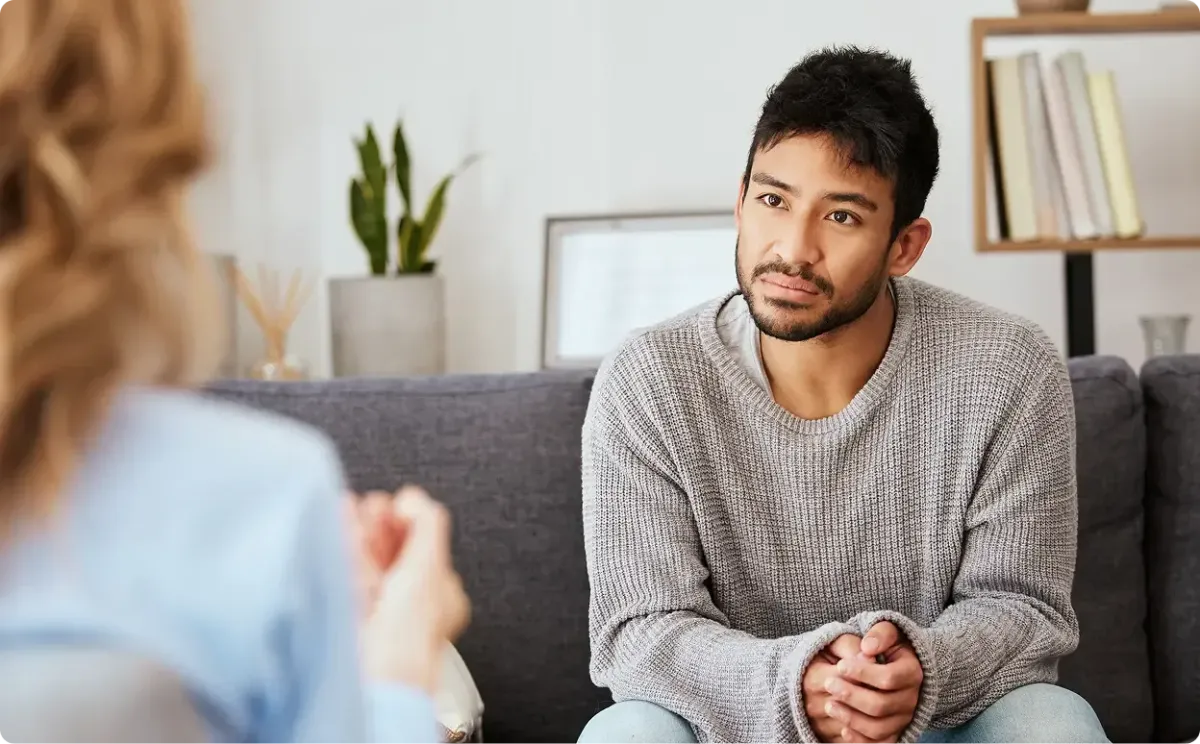 Female counselor with male patient on couch.