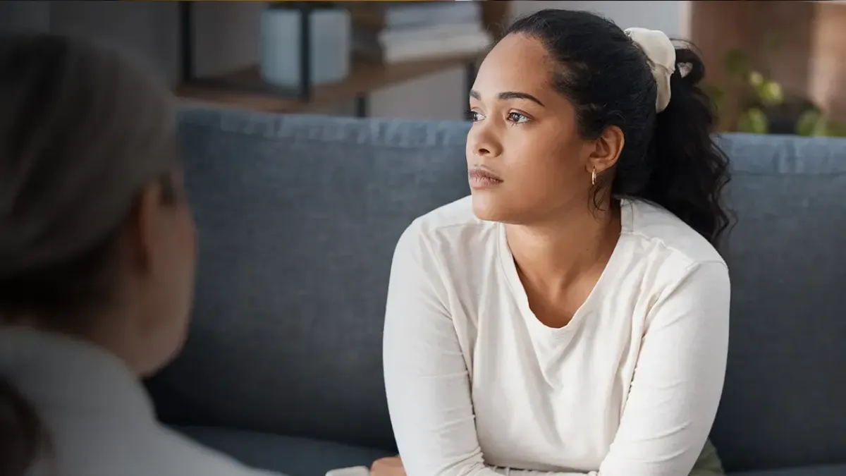 Female counselor with patient sitting on couch.