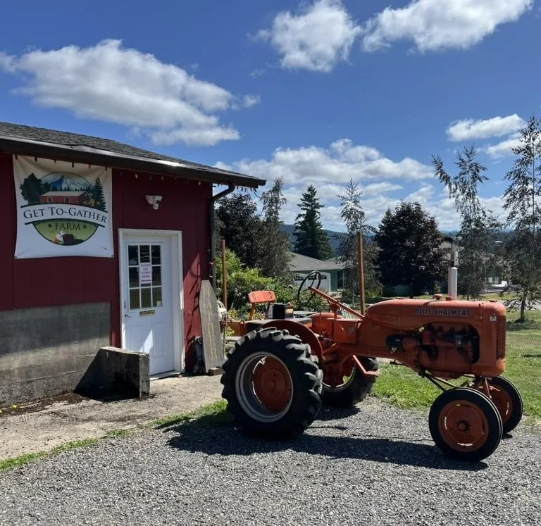 Red tractor parked in front of the farm stand.