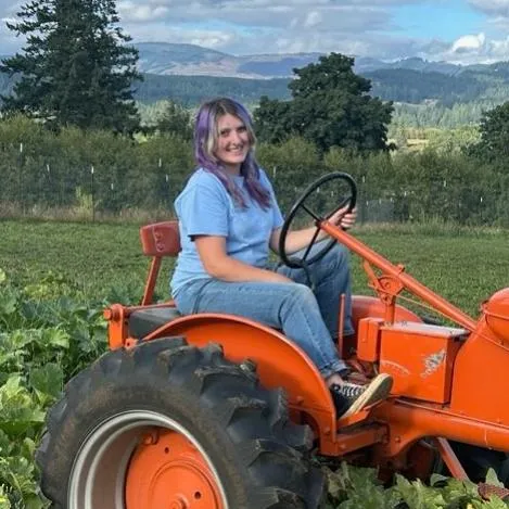 Aspen riding a tractor