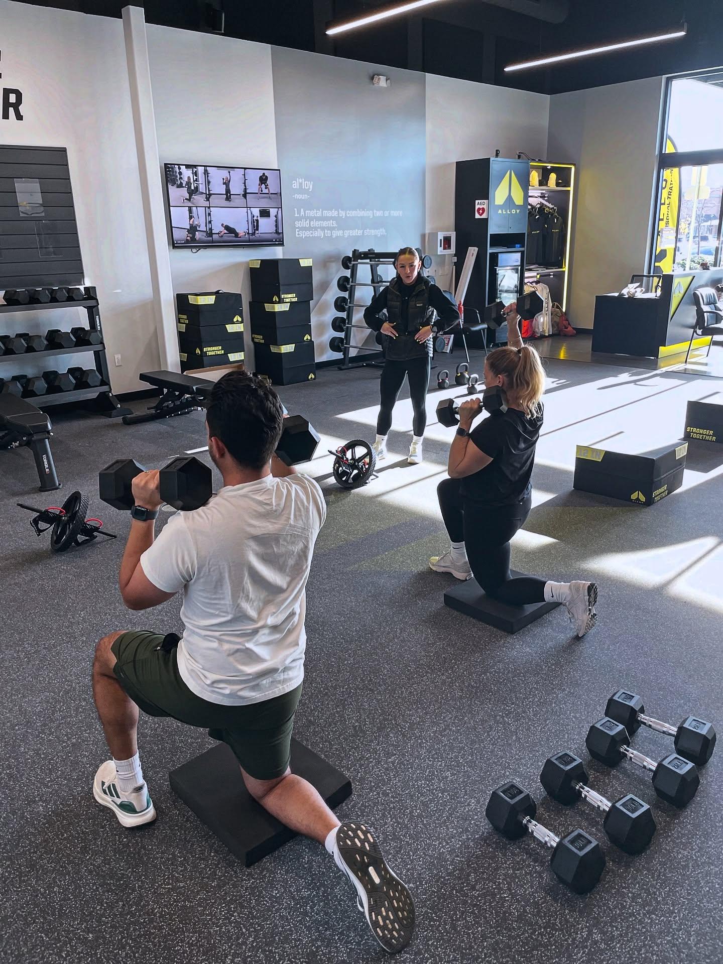 Small group personal training session at Alloy Personal Training Cedar Hills Crossing with adults performing functional strength exercises under the guidance of certified personal trainers.