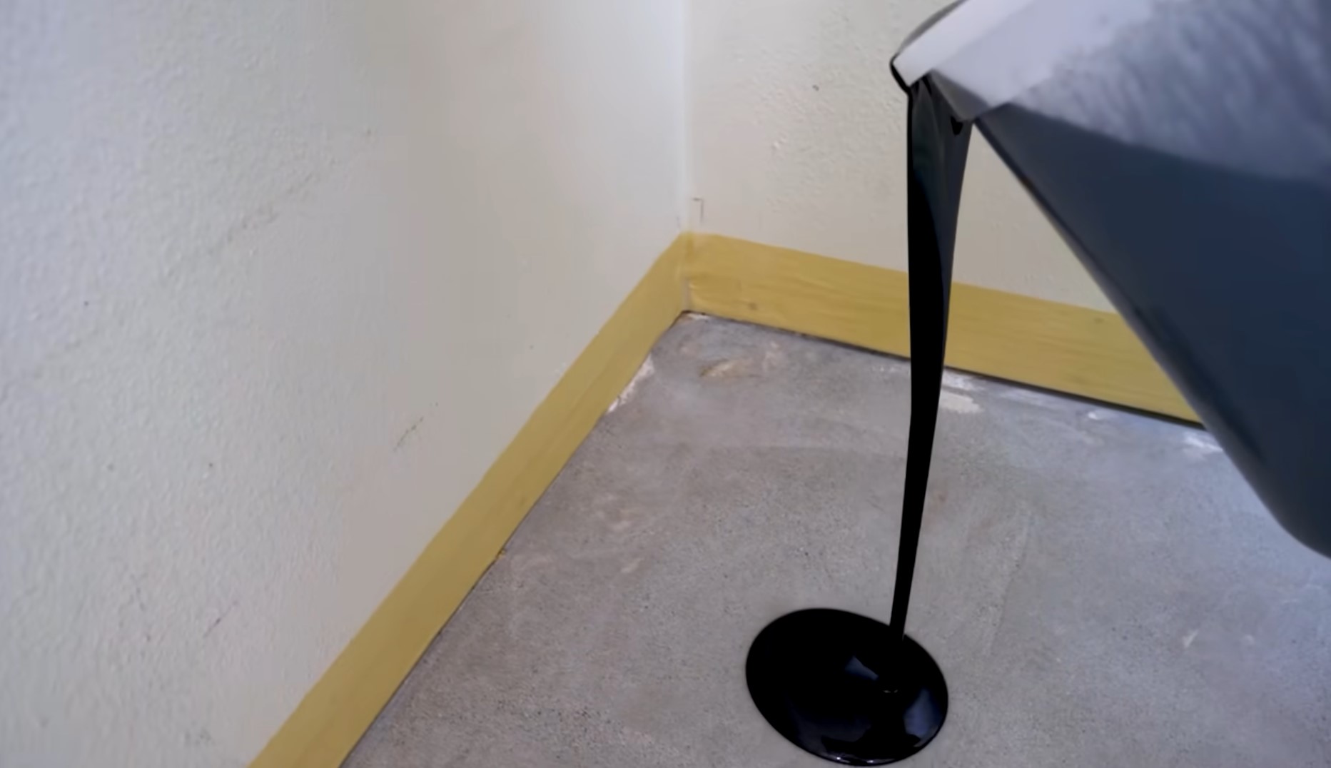 pouring black epoxy resin over concrete
