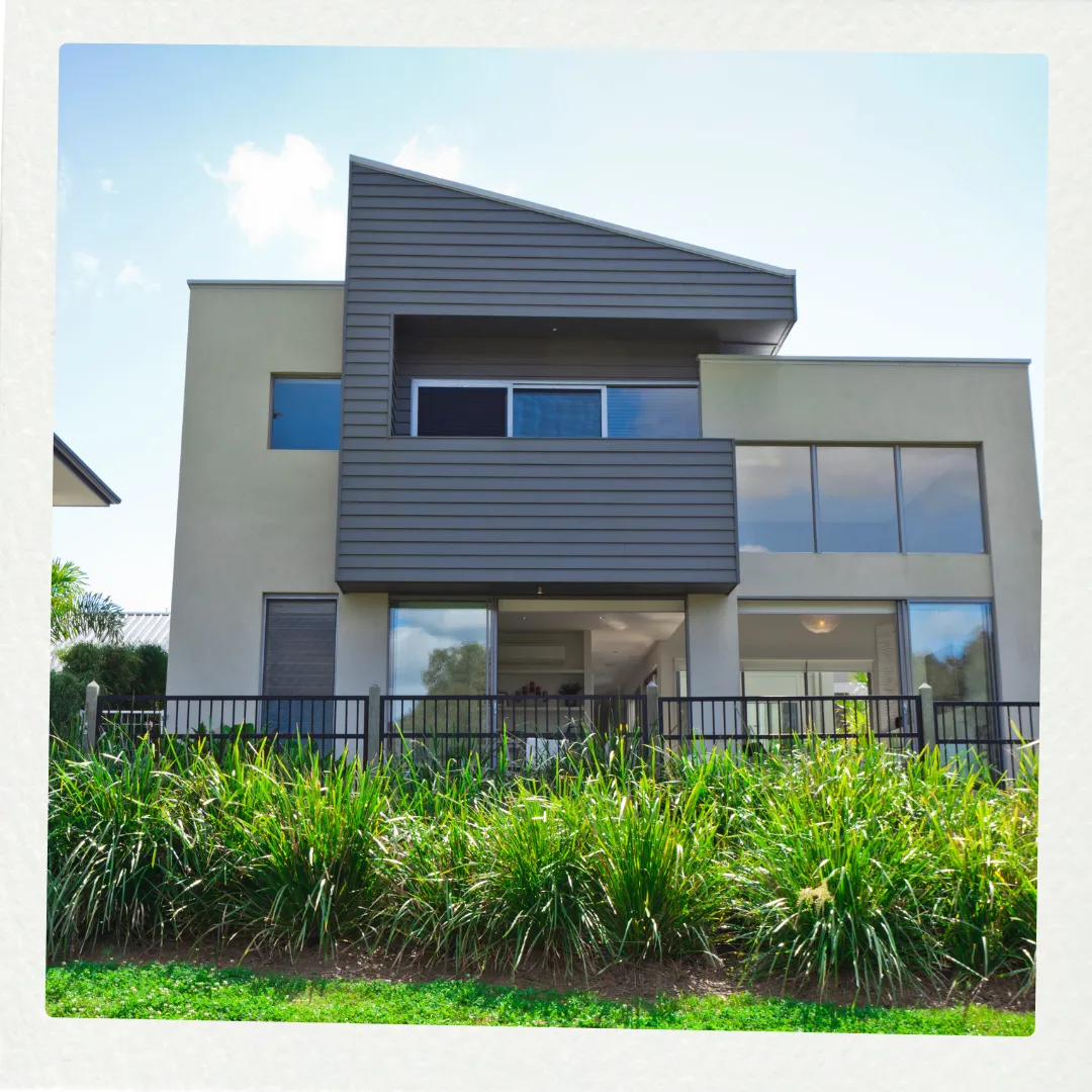 Professional exterior house painting by Phoenix Paintworks in Mildura featuring a contemporary two-story home with expertly applied light gray render and contrasting dark weatherboard cladding, demonstrating quality workmanship in mixed-material finishes.