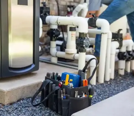 Tool bag beside a pool heat pump and PVC plumbing during a repair visit from Fort Pierce Pool Maintenance
