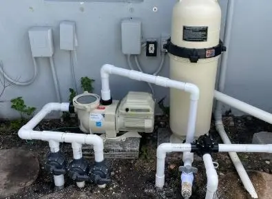 Pool pump, cartridge filter, and valve manifold on an equipment pad ready for salt cell maintenance