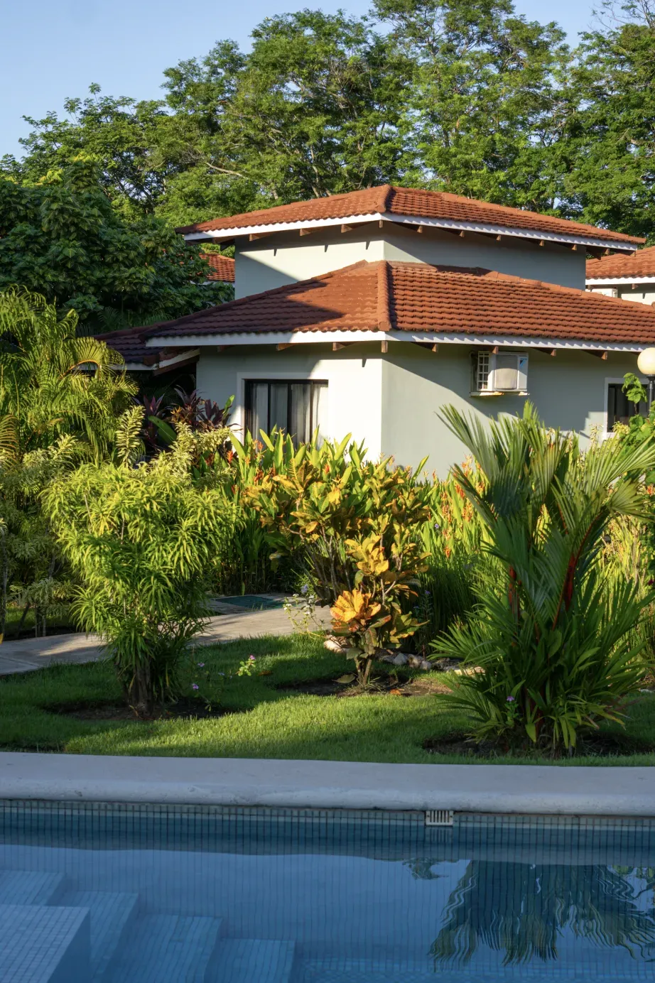 Resort-style pool with palm trees and cabanas at Villaggi