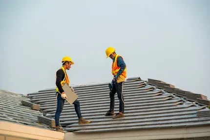 two workers standing on the roof