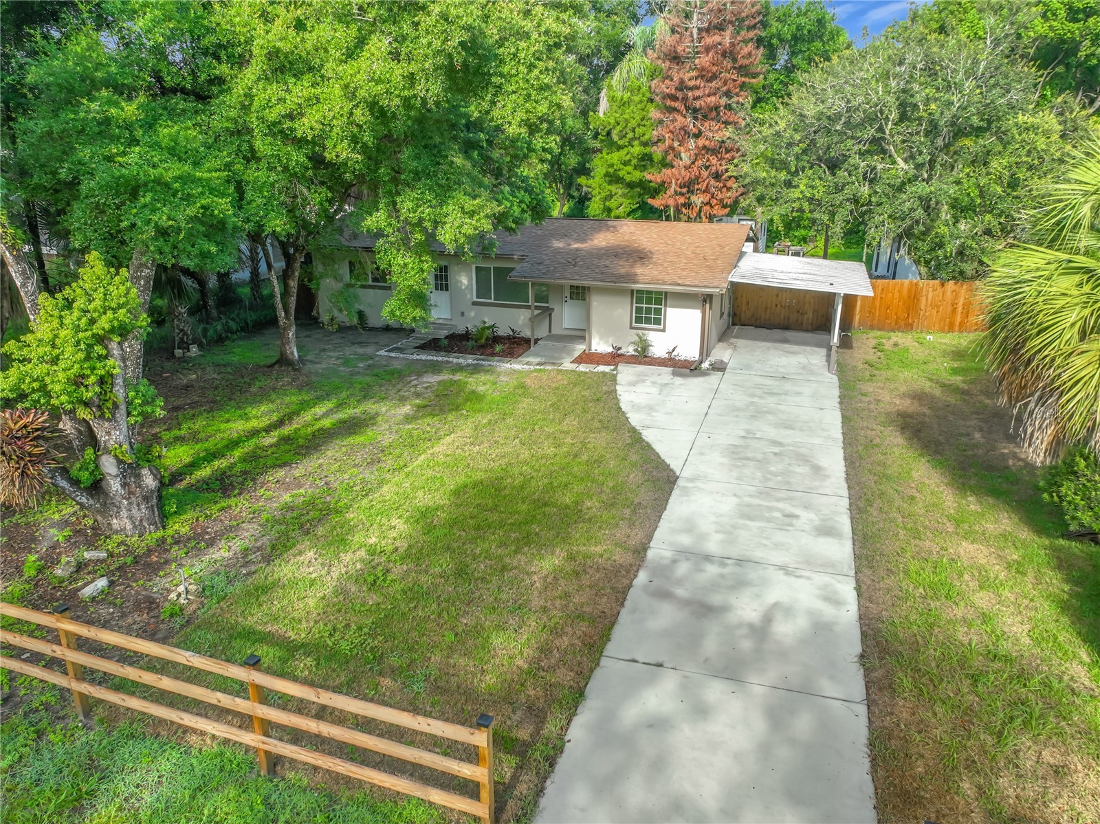 white and brown wooden house near green trees under blue sky during daytime