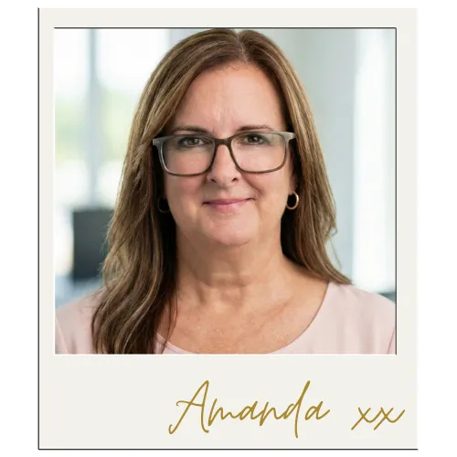 A close-up portrait of a woman with light skin, wearing stylish glasses with a black frame and gold hoop earrings. She has soft curls framing her face and wears subtle makeup with pink lipstick. She is dressed in a patterned blouse with gold detailing. The background features a modern, abstract design with green and neutral tones. The image is cropped in a circular frame.