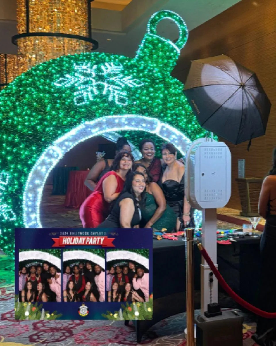 Minimal inline booth inside an elegant ballroom with marble floors, gold-accented stand and velvet rope, warm ambient lighting, subtle purple neon tube accent overhead, clean modern composition highlighting install quality and premium finish.