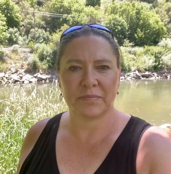 picture of a woman standing infront of a river bank