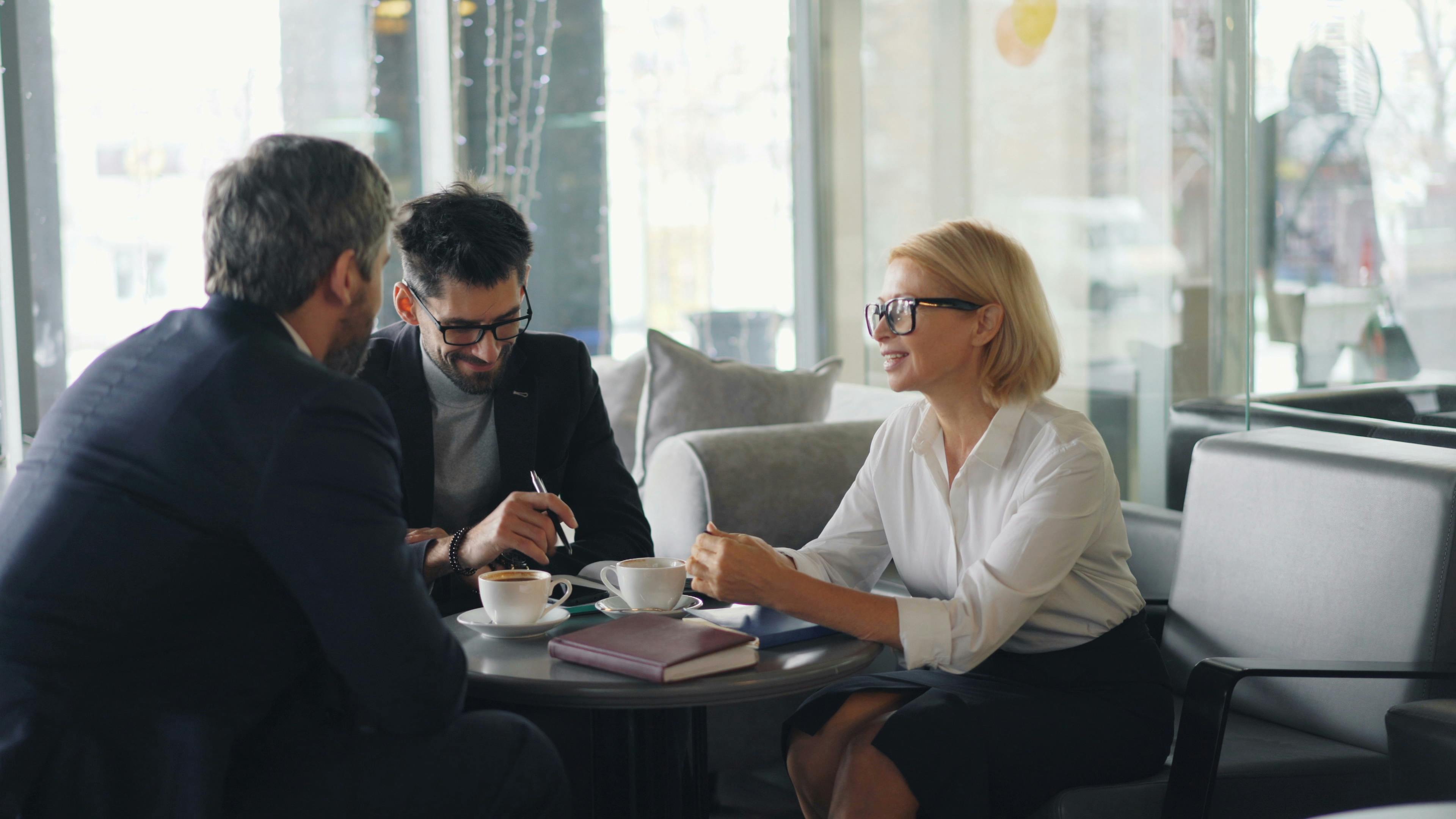 three professionals talking over coffee